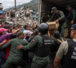 Imagen editorial de fuerzas de seguridad controlando suministros humanitarios frente a una multitud de civiles en una zona urbana afectada por un terremoto, utilizada para ilustrar denuncias sobre desvío de ayuda y obstáculos al rescate en Venezuela.